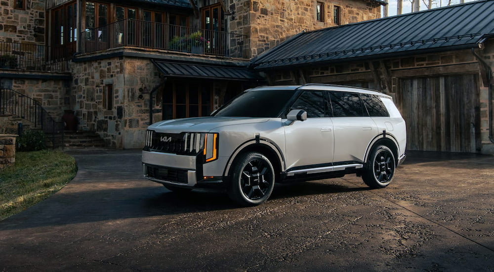 White 2027 Kia Telluride parked on a driveway outside a house.