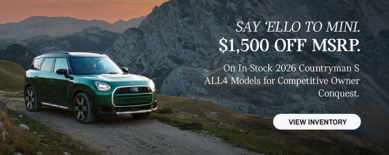 Front passenger side view of a MINI Countryman  driving on a mountainous road.