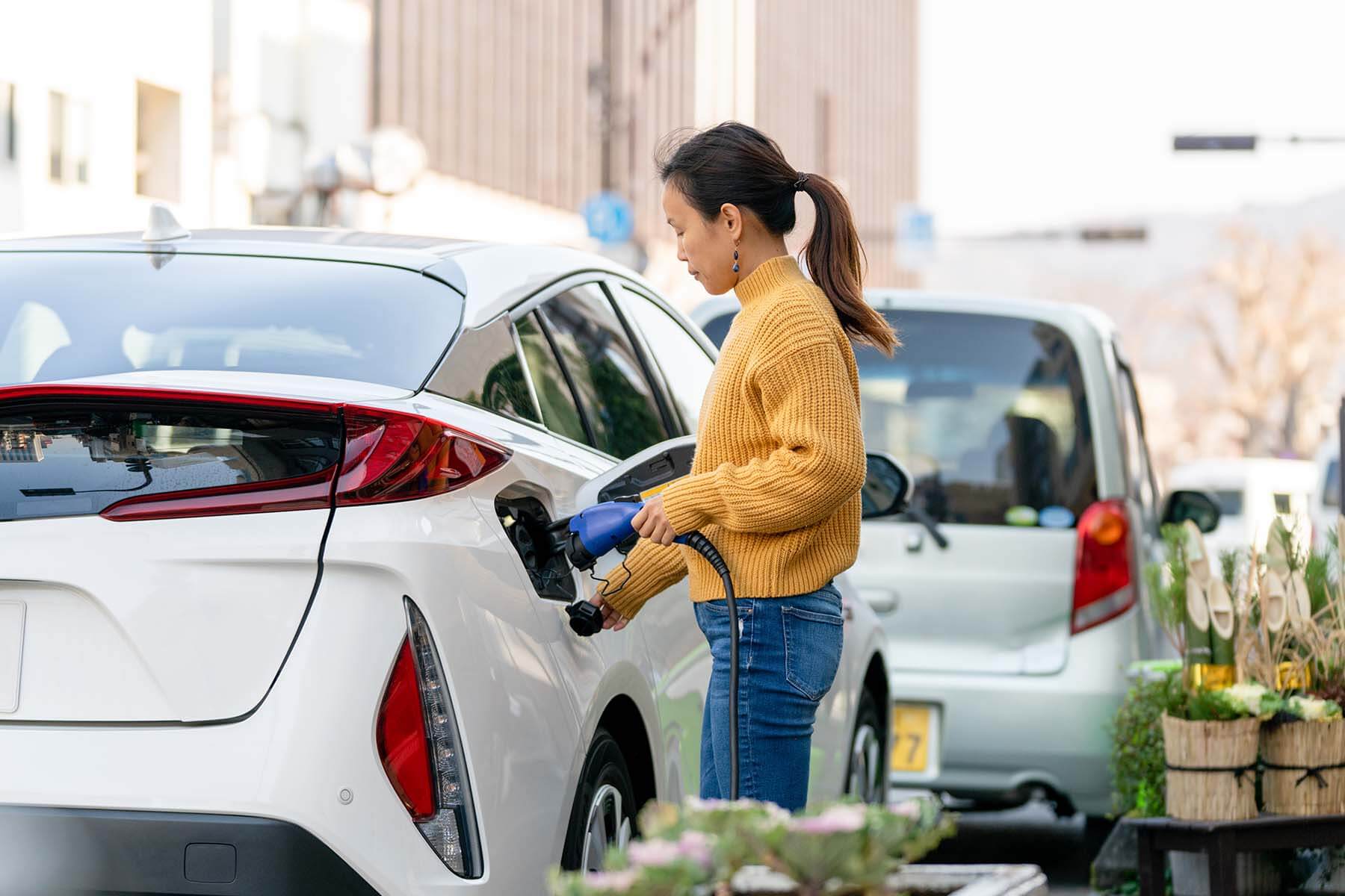 woman charging her white plug in hybrid