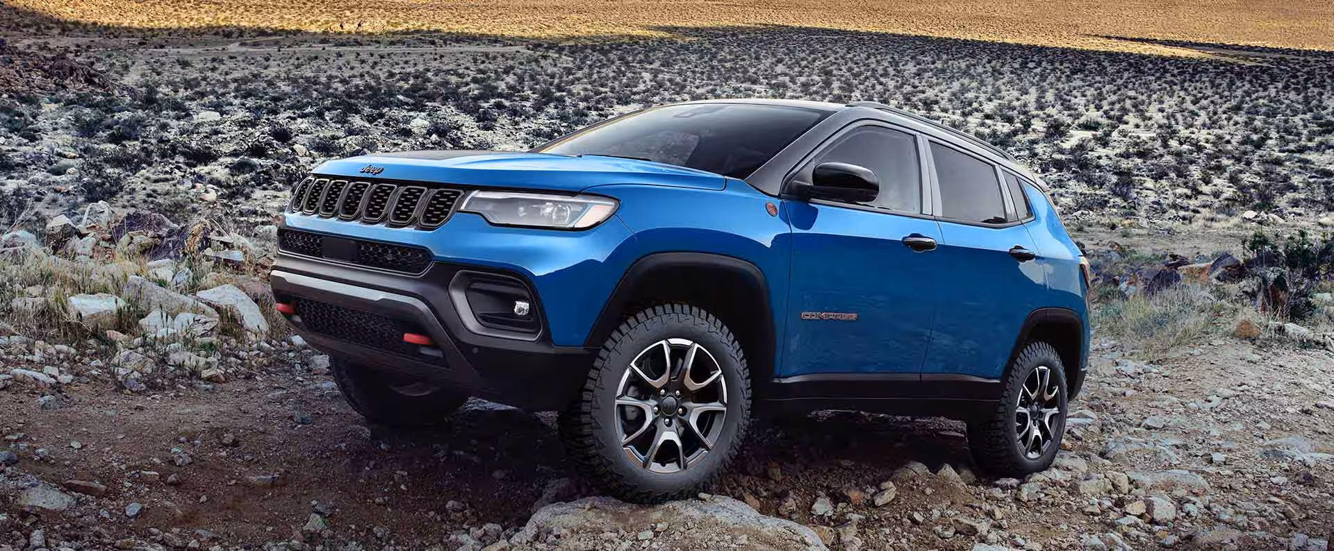 A blue car sitting parked off-road.