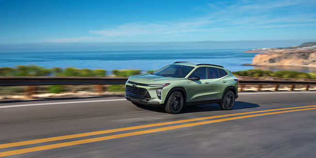 A green car driving on the road.