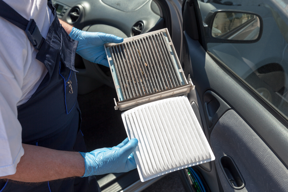 a mechanic compares an old, dirty, air filter with the new, clean one