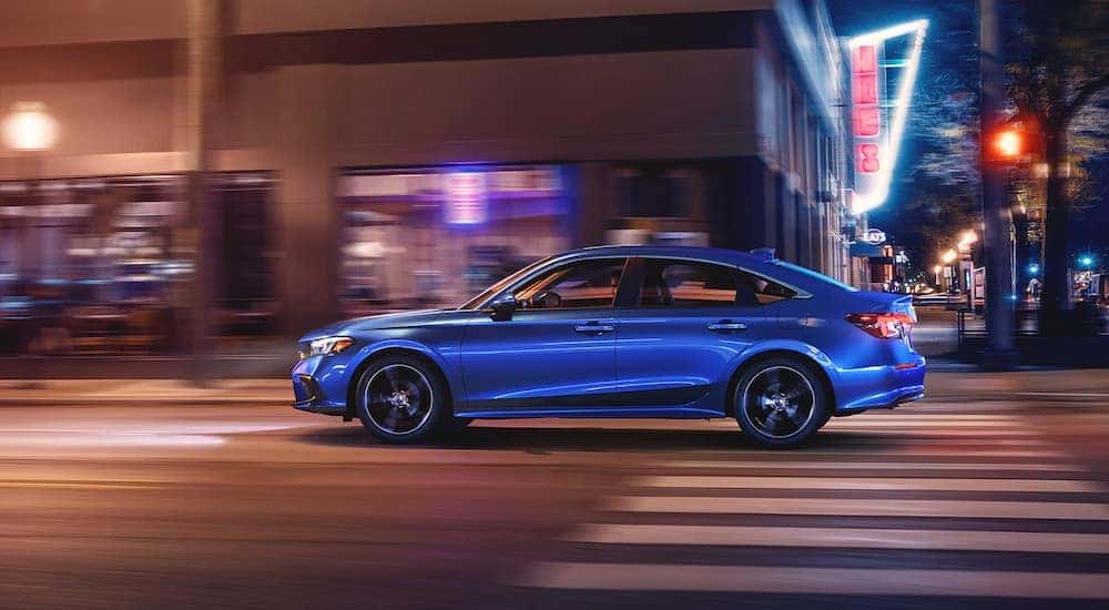A blue 2022 Honda Civic Sport is shown from the side leaving a Honda dealer near you.