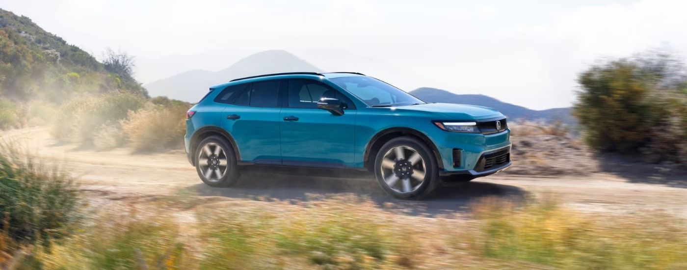 Teal 2024 Honda Prologue is shown driving on a dirt road
