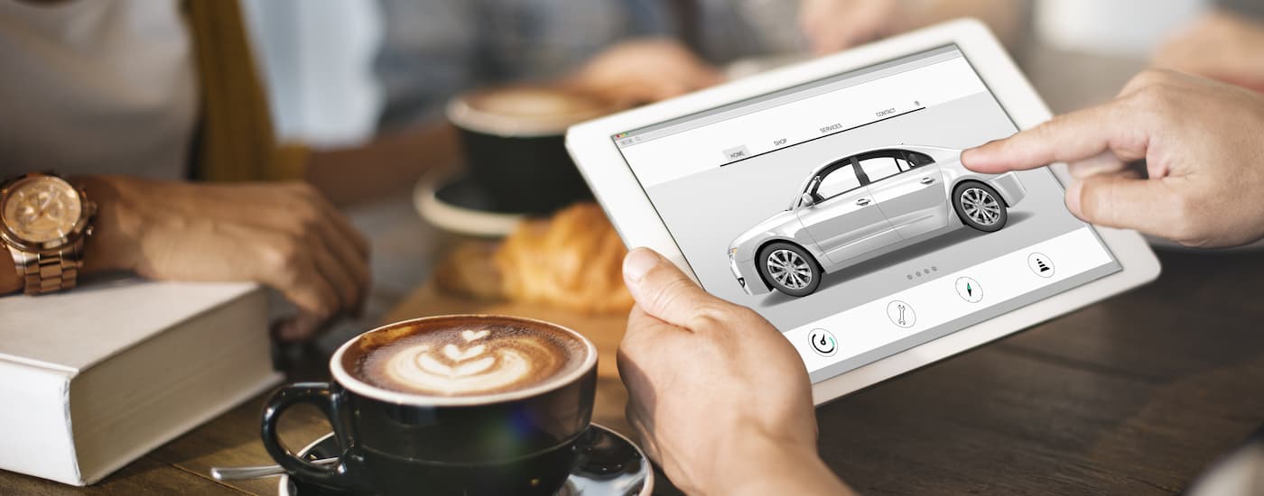 Person looking at a car on a tablet.