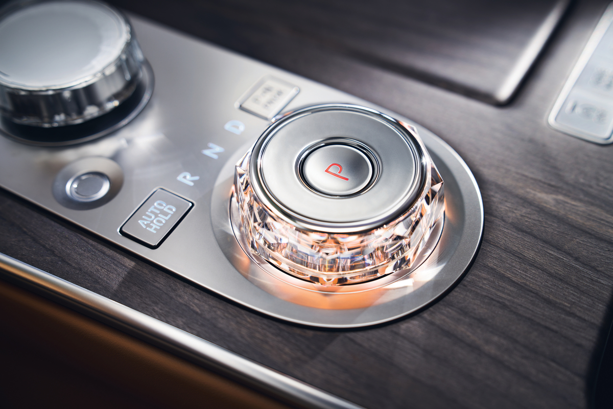 Interior close up shift by wire gear selector wheel with red ambient light inside the Genesis G80