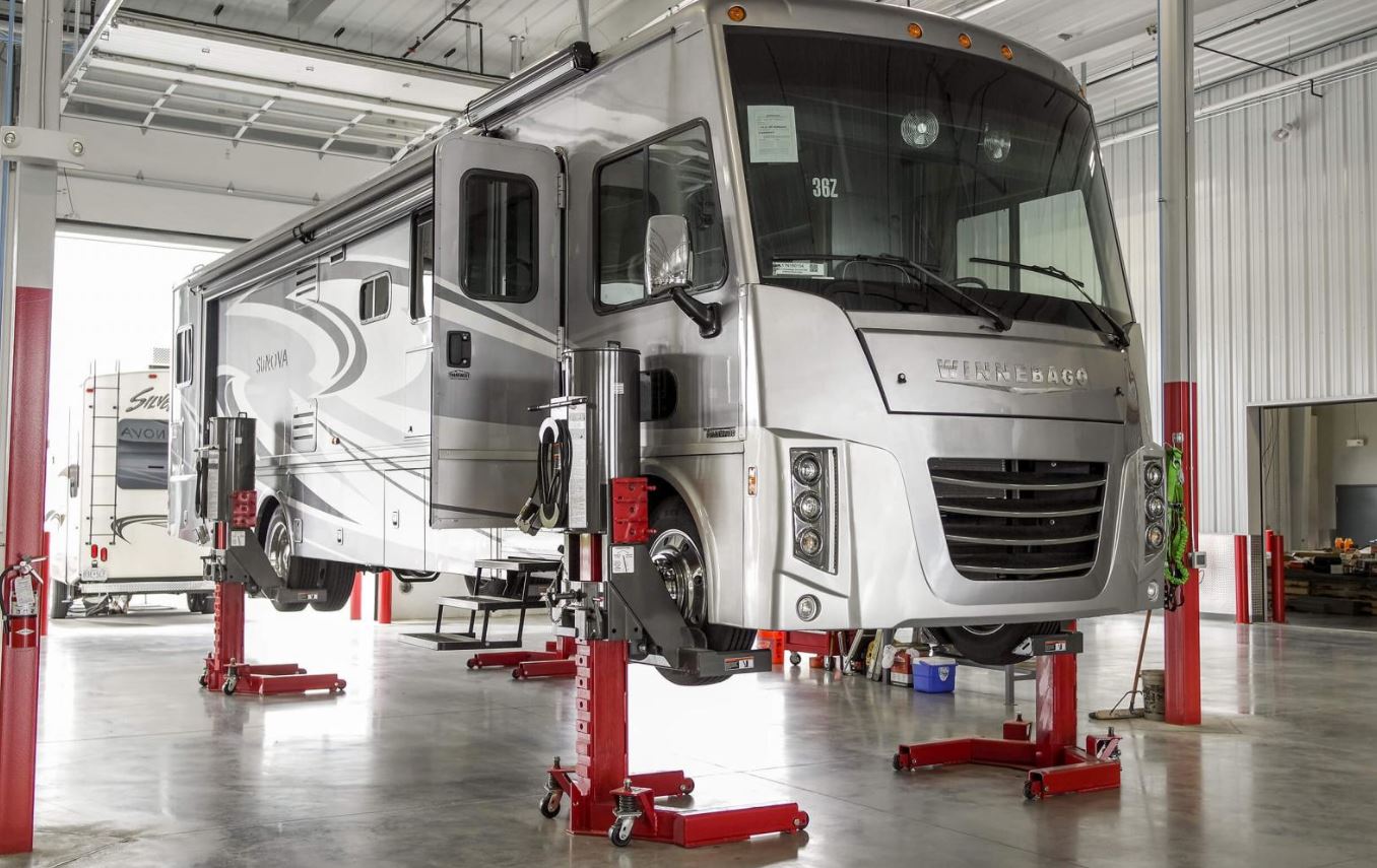 a raised RV in a Kunes RV service bay