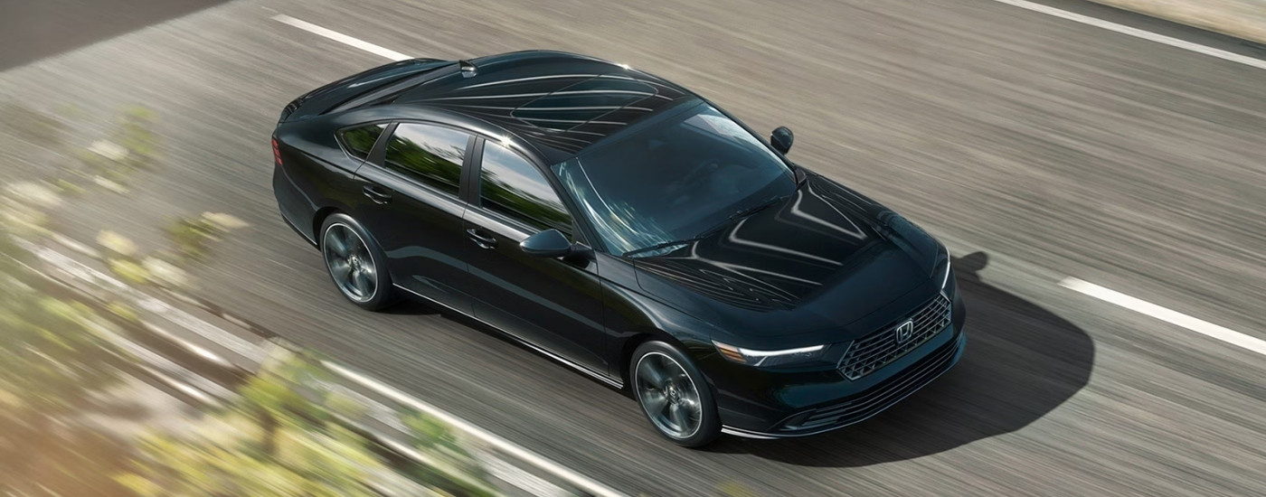 Black 2026 Honda Accord Hybrid Sport-L driving on a highway