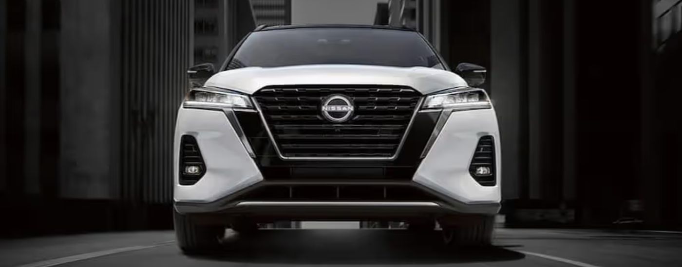 The front grille of a white 2024 Nissan Kicks.