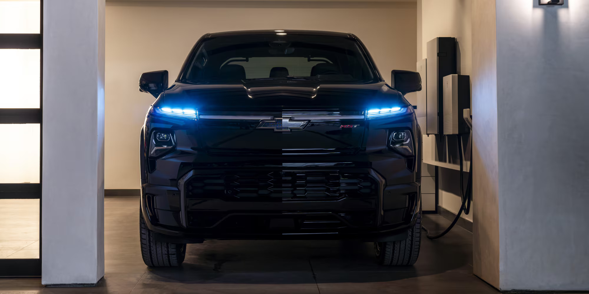 A black truck sitting in a garage getting charged.