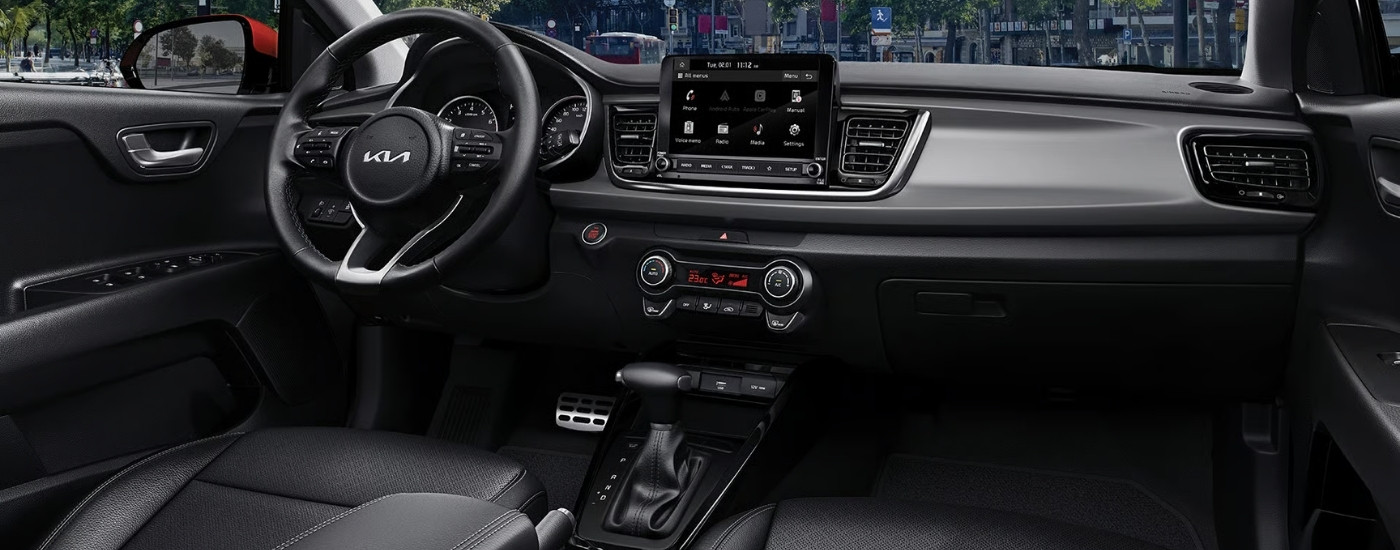 Black dashboard and center console in a 2023 Kia Rio