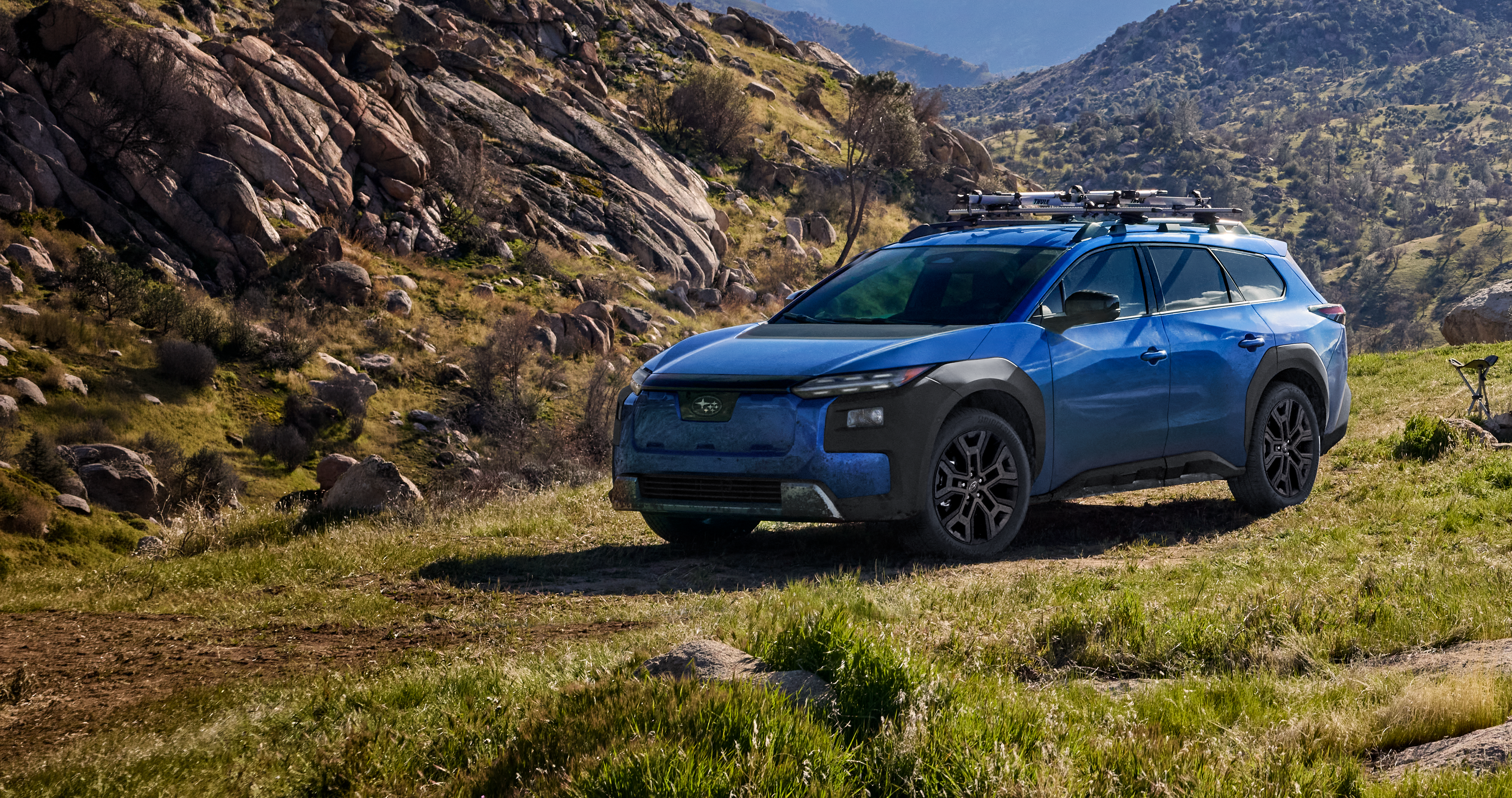A 2026 Subaru Trailseeker in blue drives down an arid hill.