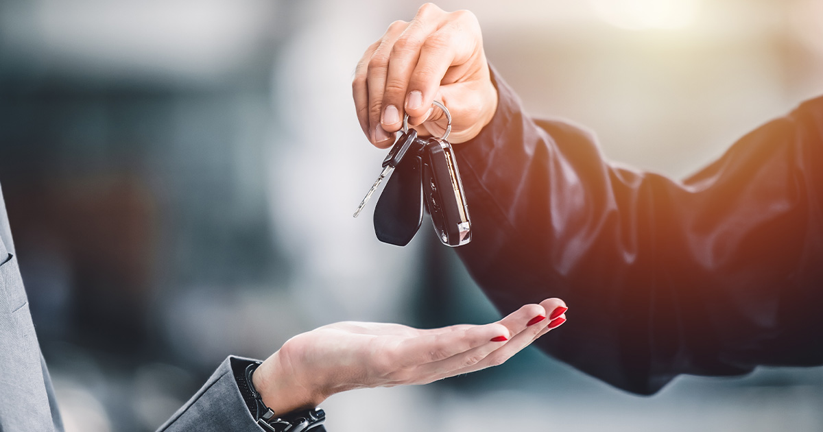 A person handing over a set of car keys to another person.