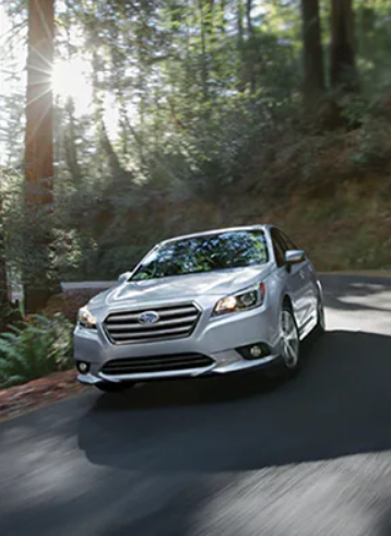 Subaru Legacy in silver driving in a moderate environment.