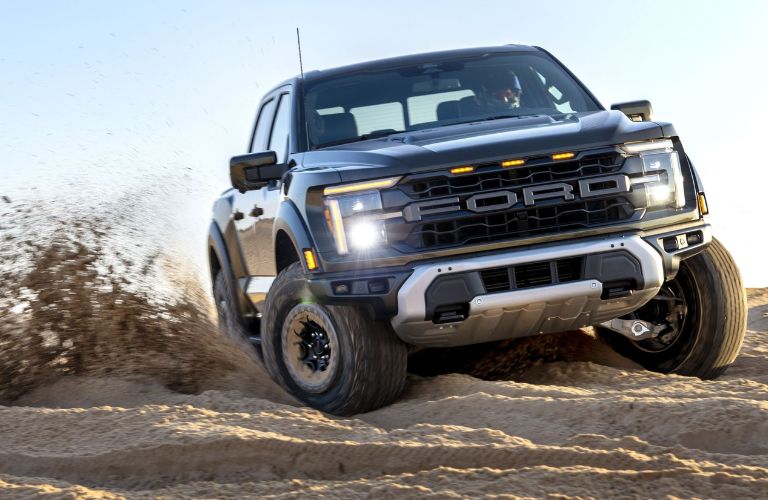 Black 2024 Ford F-150 Raptor Kicking Up Sand on Trail