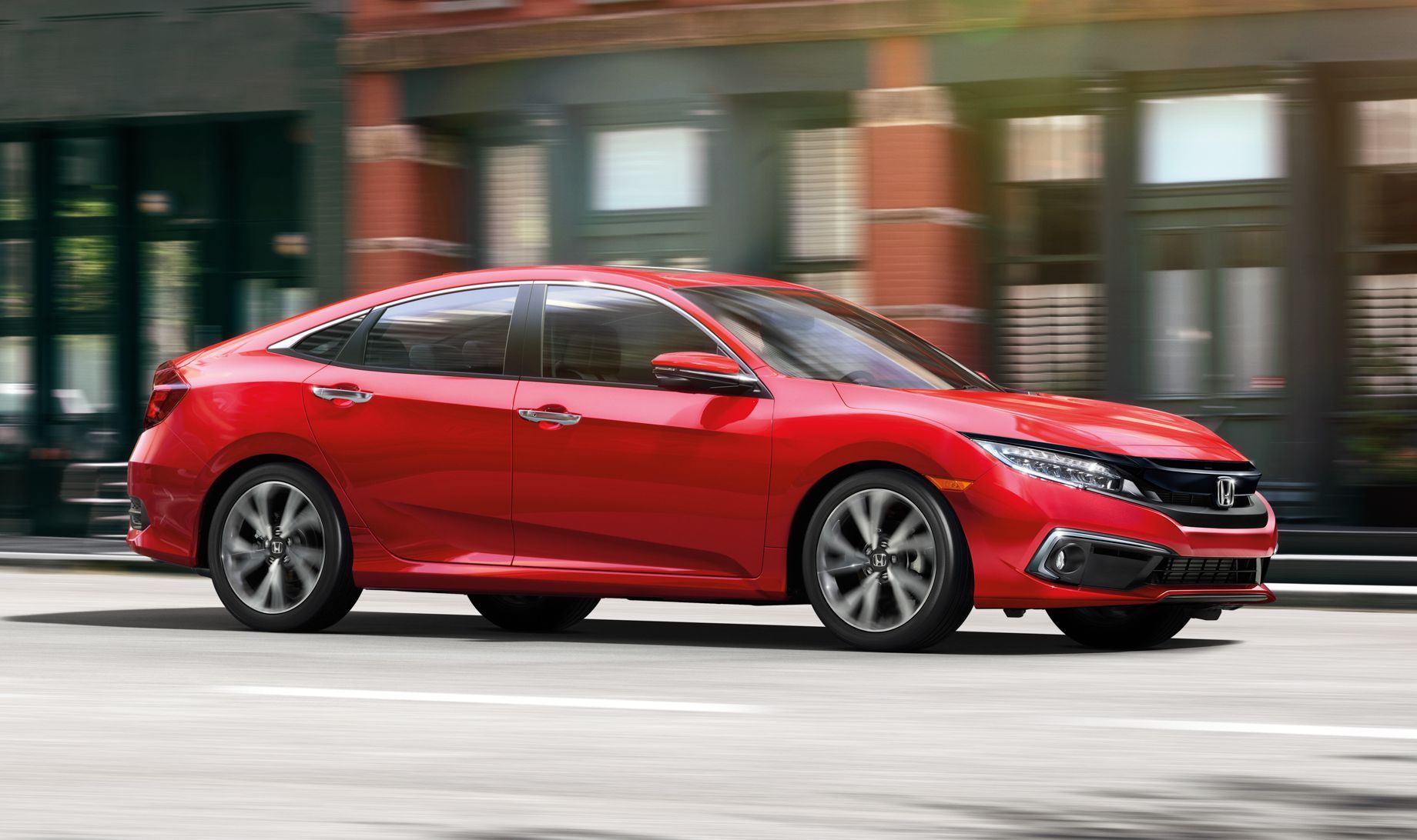 red 2019 Honda Civic driving through a city