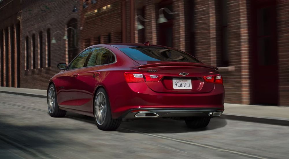 Red 2023 Chevy Malibu RS driving on a city street