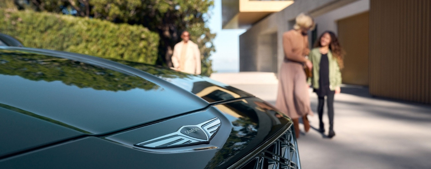 Family walking toward a black  2025 Genesis GV80 SUV