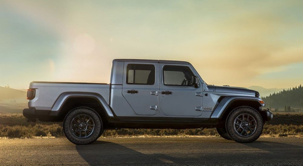 A grey 2023 Jeep Gladiator is shown from the side on a cloudy day.