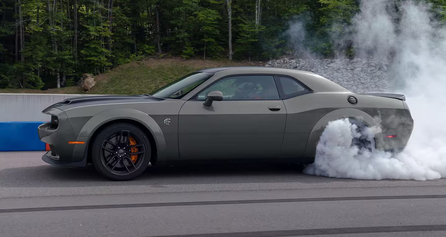 A gray Dodge Challenger burning out.