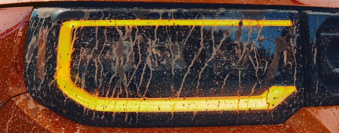 Muddy headlight on an orange 2026 Honda Passport TrailSport Elite 