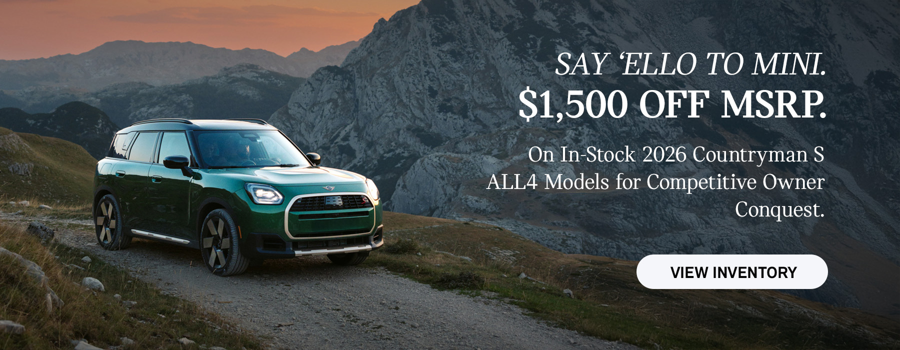 Front passenger side view of a MINI Countryman  driving on a mountainous road.