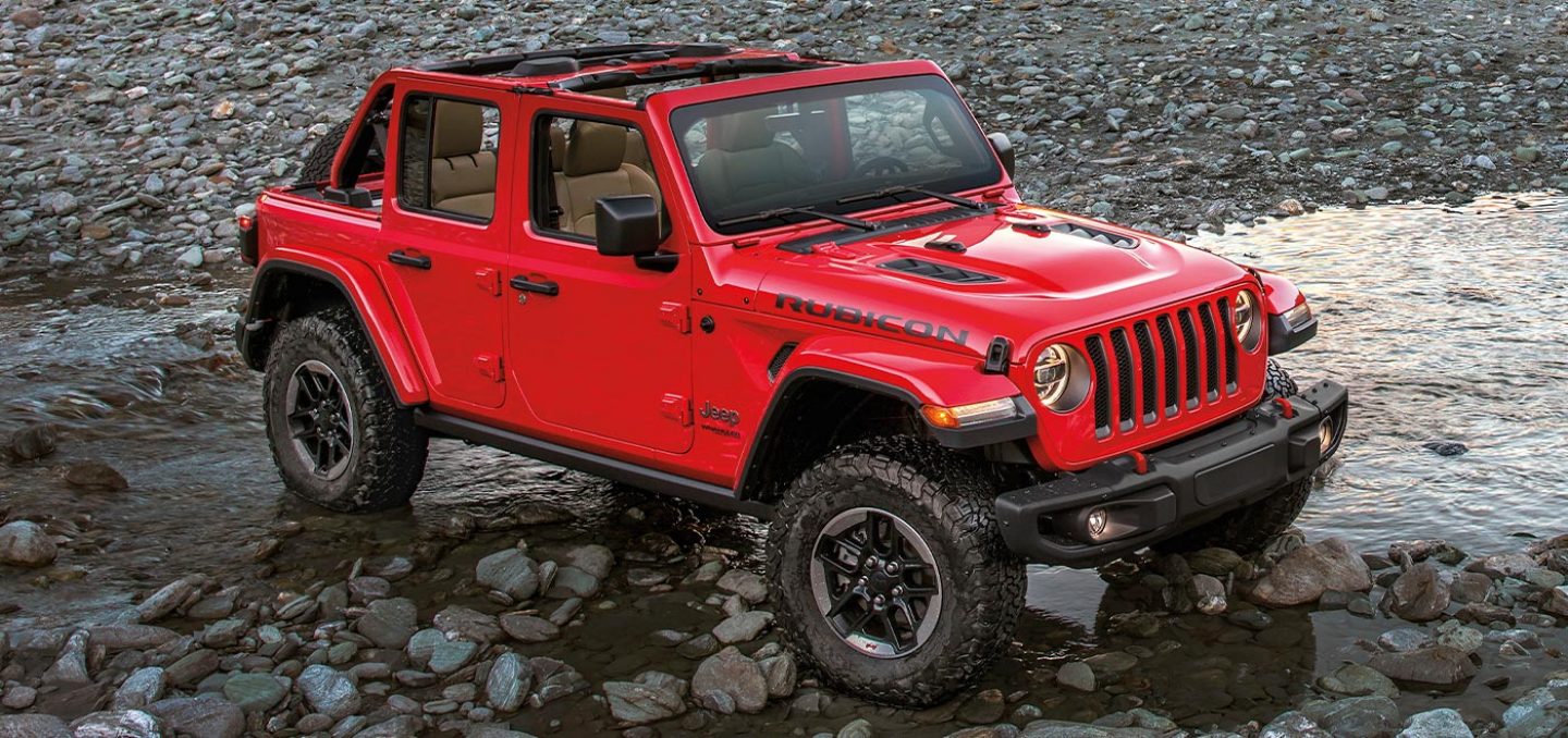 a red suv parked in a bedrock river