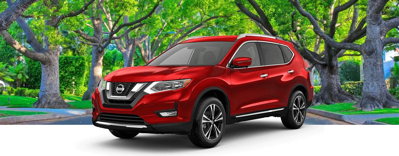 Red 2017 Nissan Rogue SUV in front of a tree-lined street