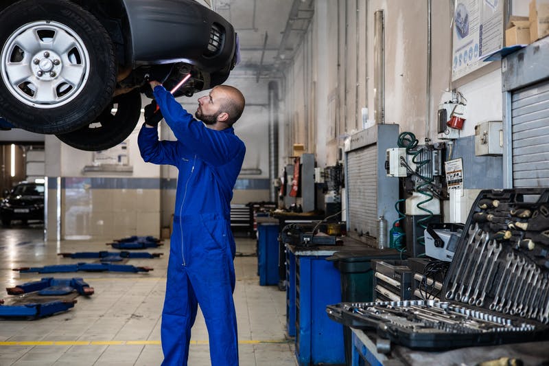 A mechanic servicing a car in a service center