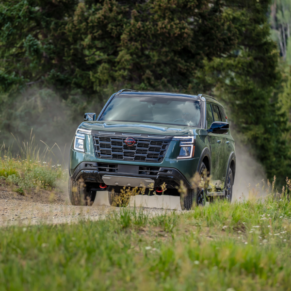 Green 2025 Nissan Armada driving on a dirt road.