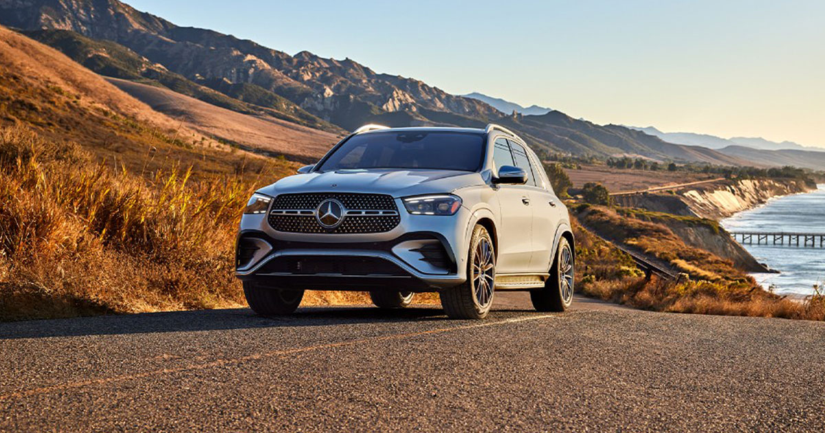 A silver Mercedes-Benz GLE up the road from a lake
