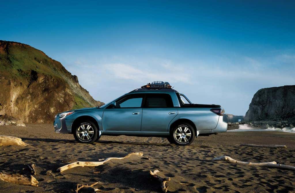 Light blue Subaru Baja concept pickup parked on a rocky beach
