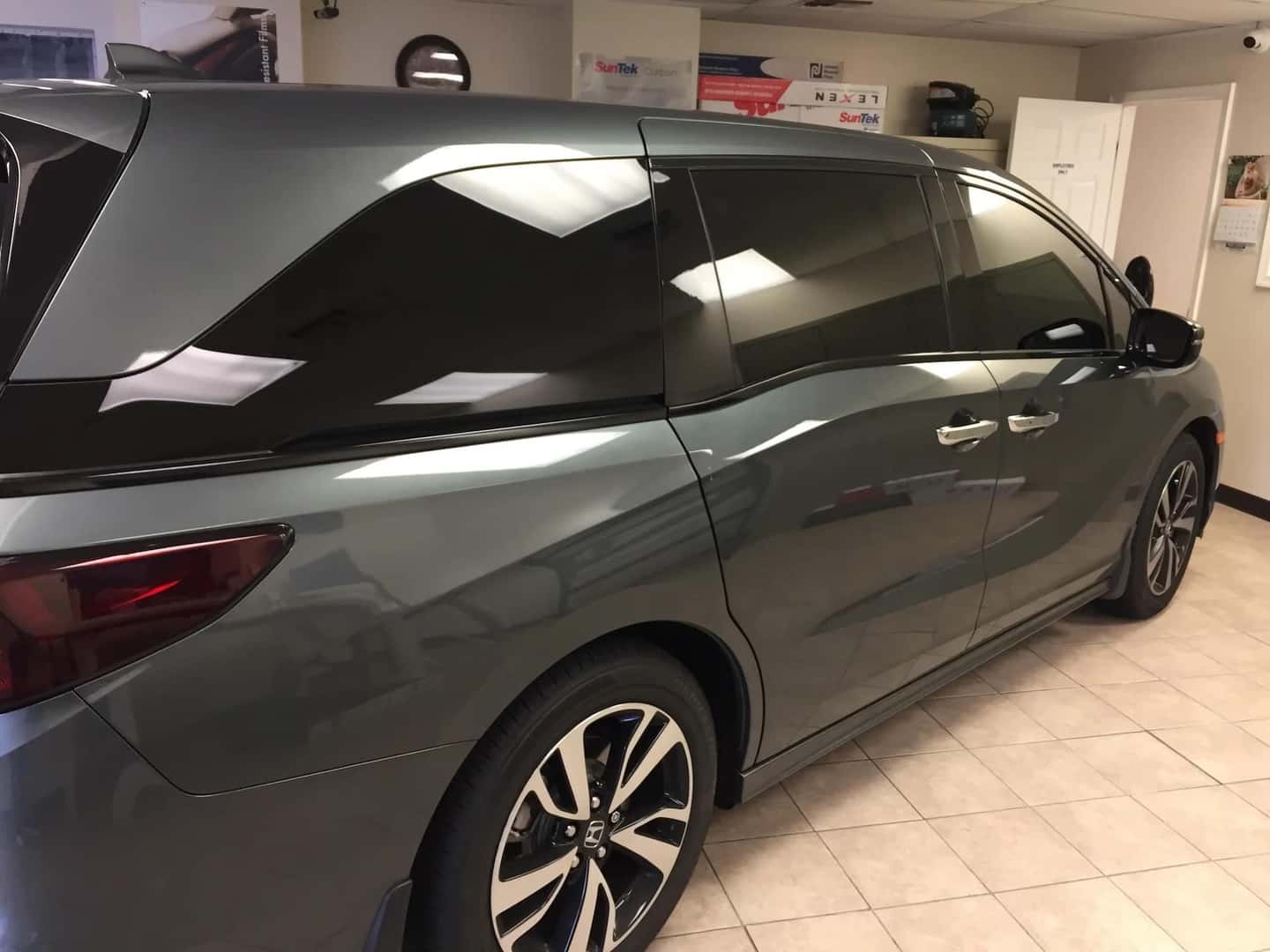Gray minivan with tinted windows parked in a garage