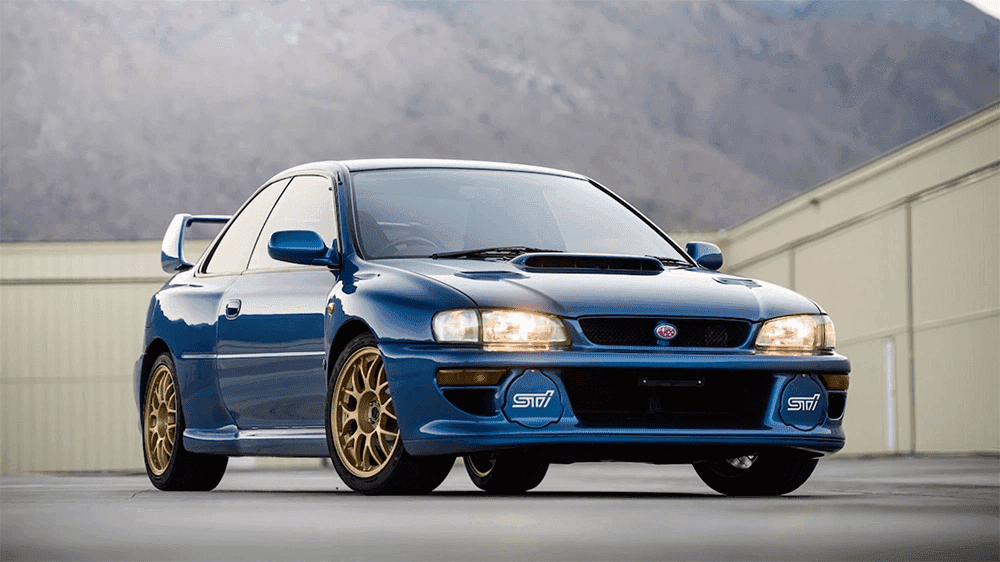 Blue 1998 Subaru Impreza 22B STi with gold wheels, front three-quarter view