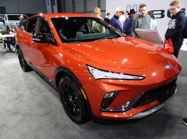 2024 Buick Envista Sport Touring in orange paint parked in a showrrom.