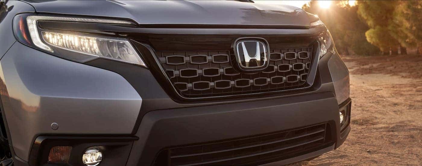 A close up shows the front grille and headlights on a gray 2021 Honda Passport.