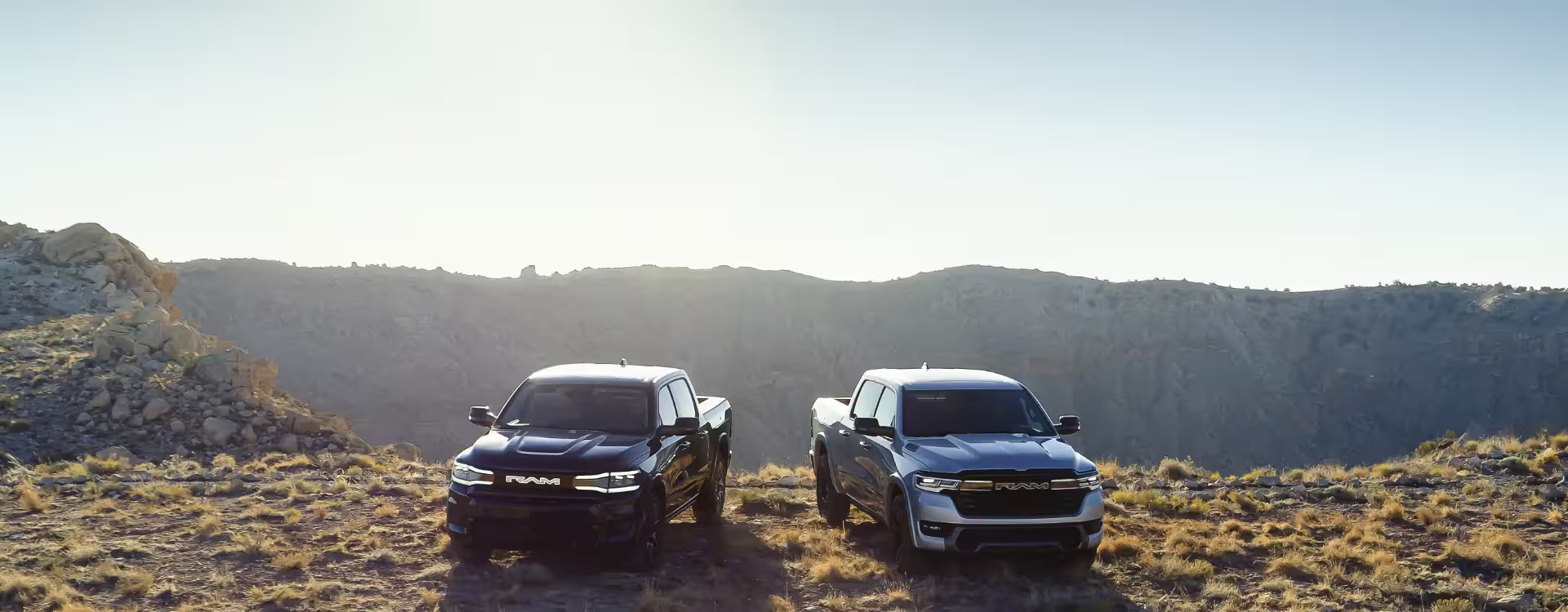 Two RAM trucks sitting majestically near a western valley.