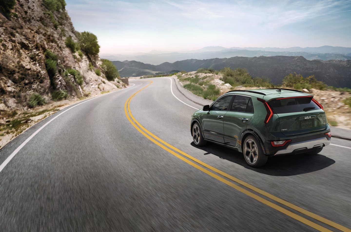 Green SUV driving on a winding mountain road