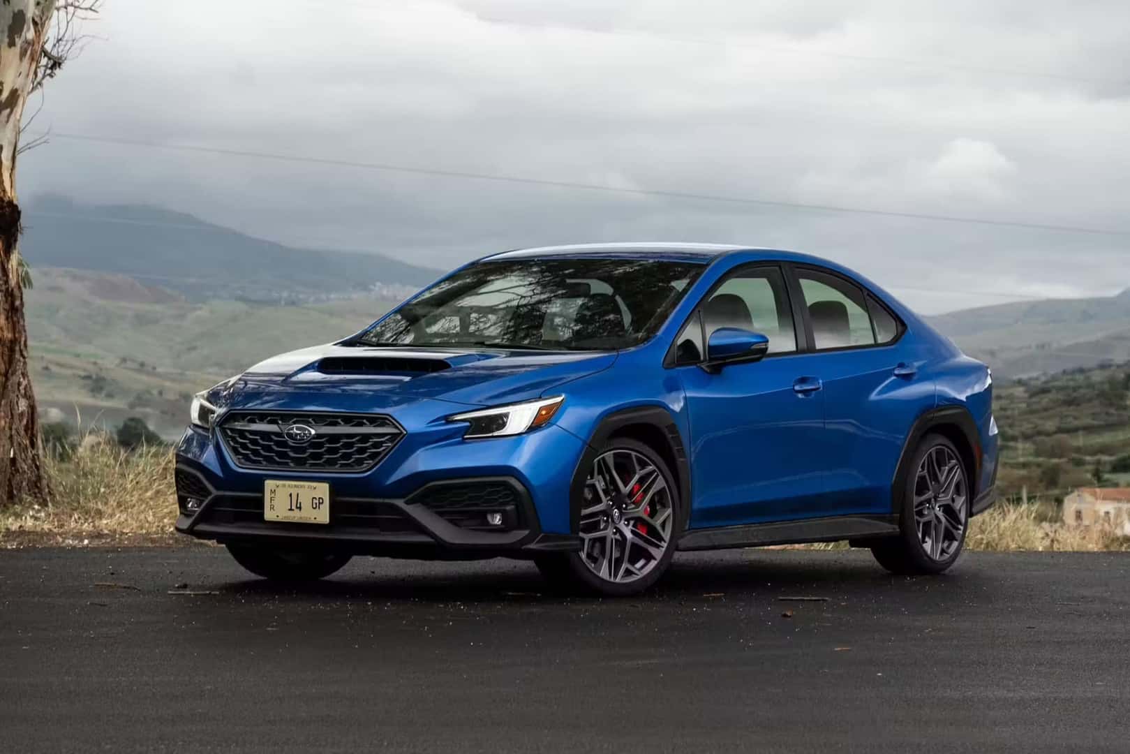 Blue 2024 Subaru WRX TR parked under a cloudy sky