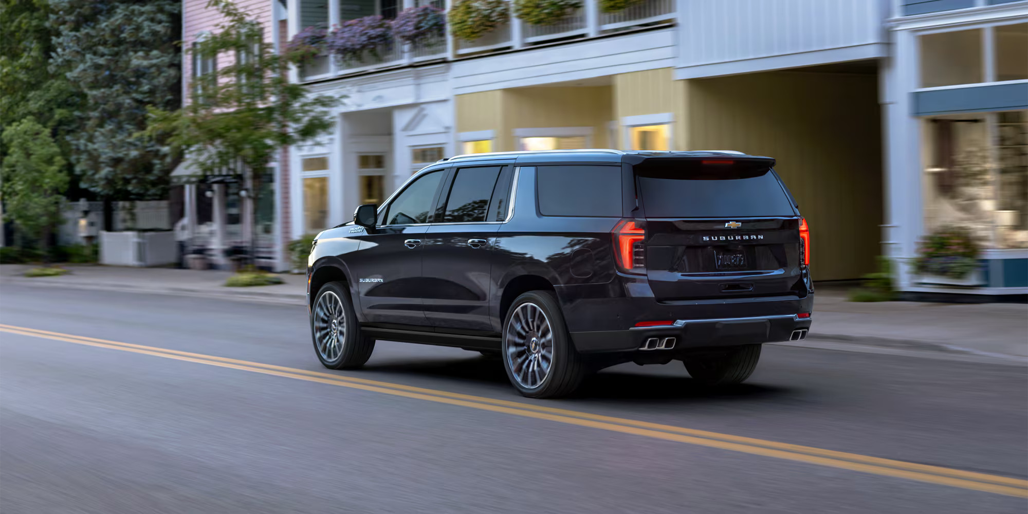 A black suv driving on a road.