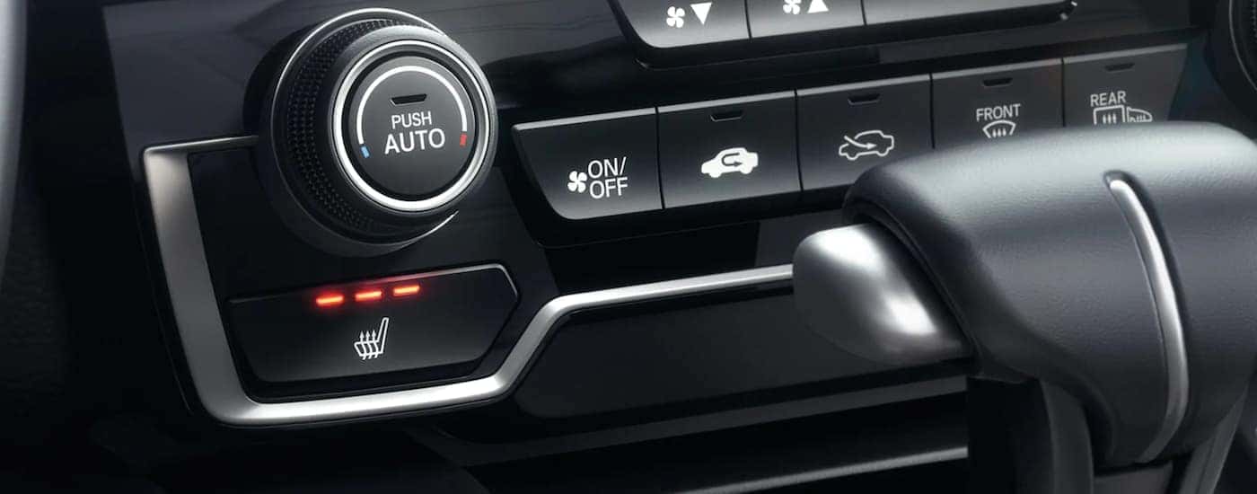 A close up shows the silver and black climate controls in a 2021 Honda CR-V.