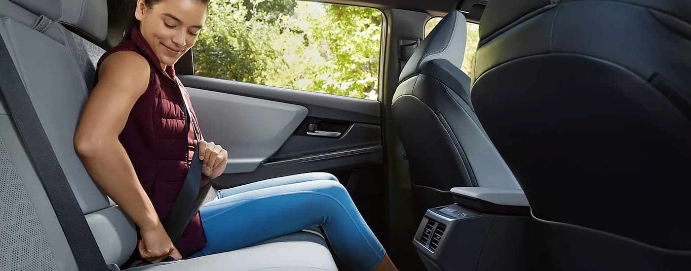 Woman buckling the seat belt in the back of a 2026 Subaru Solterra