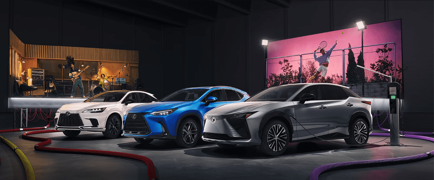 Three electrified Lexus models lined up in front of two billboards with a band and tennis player