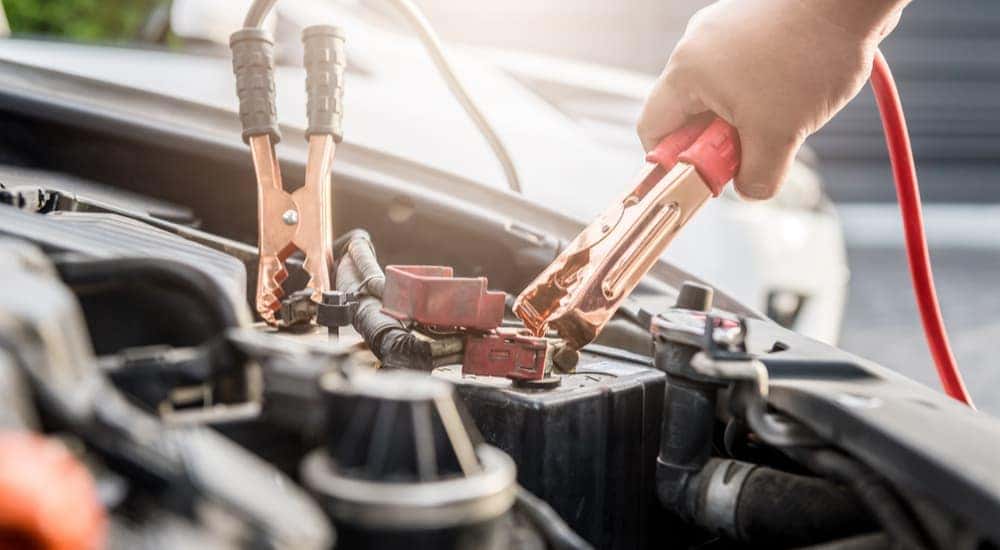 A mechanic jump starting a vehicle at a Irondequoit Honda Dealer