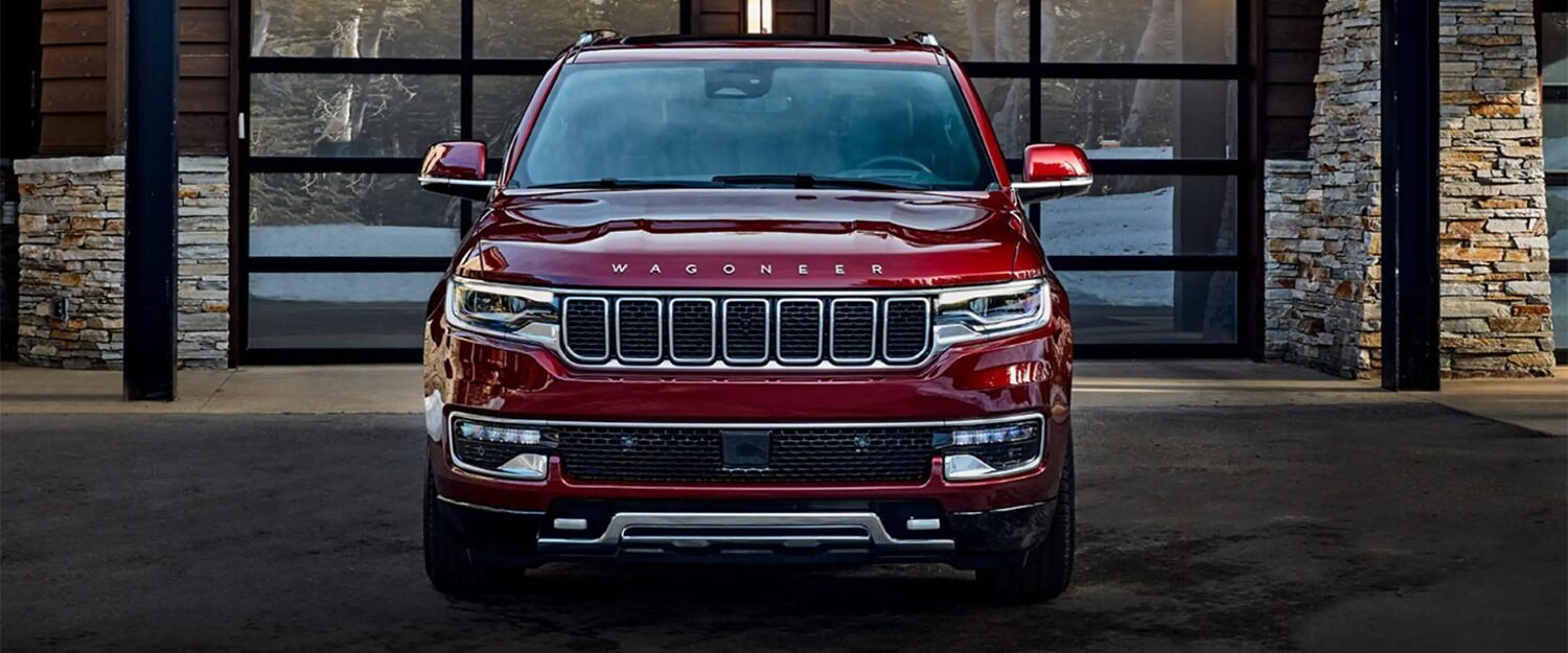 A maroon jeep wagoneer parked.