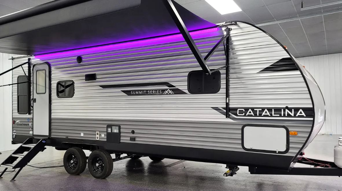 Coachmen Catalina Series 8 Travel Trailer exterior, with awning open and purple LED strip at the base of the awning turned on