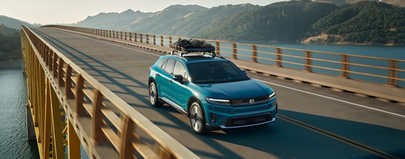 A green 2024 Honda Prologue Elite driving over a bridge