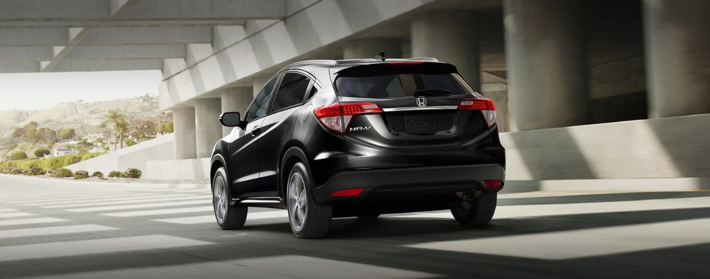 A black 2020 Honda HR-V is shown from a rear angle leaving a Rochester used Honda dealer.