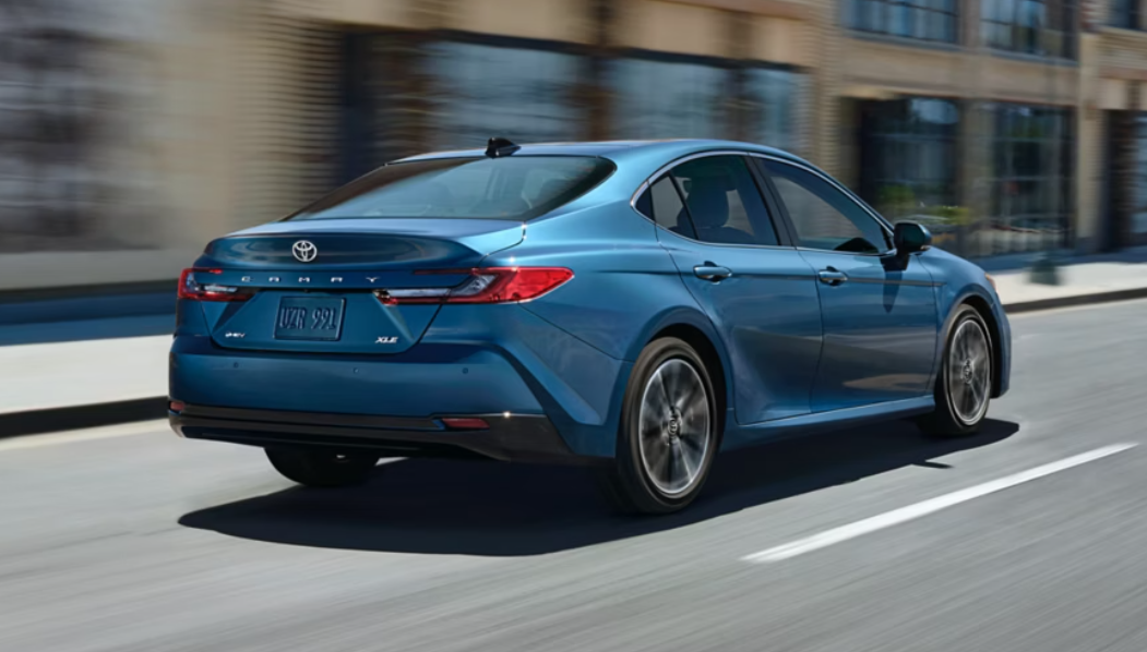 2025 Toyota Camry in blue paint driving down a Kirksville, MO city street.