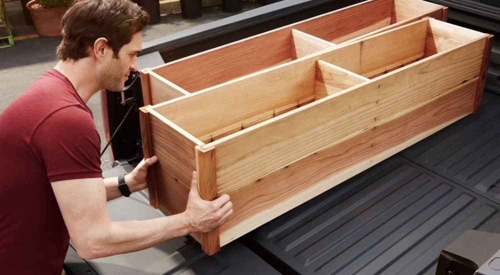 Person loading wooden shelves in a 2026 Honda Ridgeline RTL-E